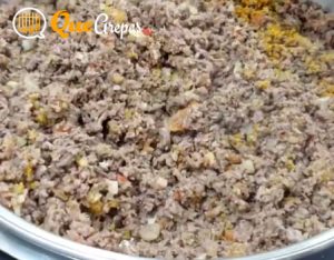 Adding the meat to the mixture - bandeja paisa - quearepas.com